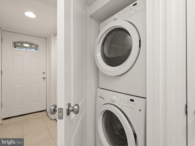 laundry room with light tile patterned floors and stacked washing maching and dryer