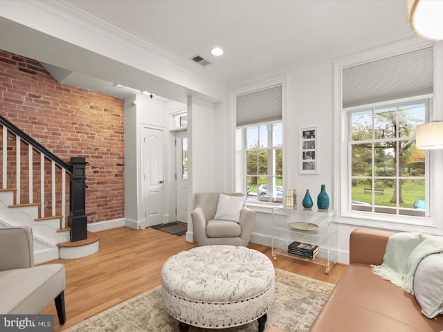 living room with a wealth of natural light, wood-type flooring, and ornamental molding