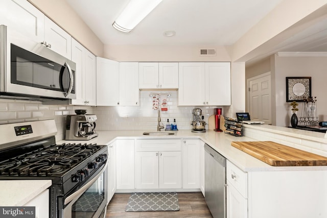 kitchen featuring white cabinetry, appliances with stainless steel finishes, light countertops, and a sink