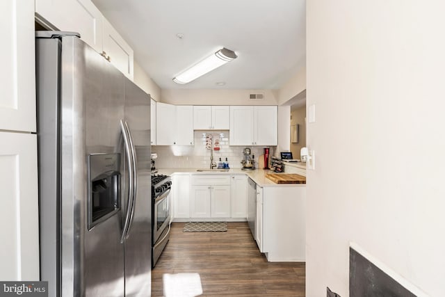 kitchen featuring appliances with stainless steel finishes, wood counters, white cabinets, backsplash, and sink