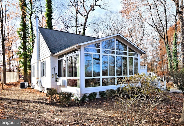 view of side of property featuring a sunroom and cooling unit