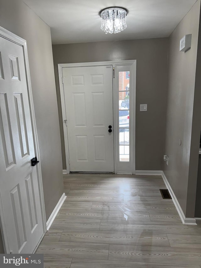 foyer featuring a notable chandelier and light hardwood / wood-style floors