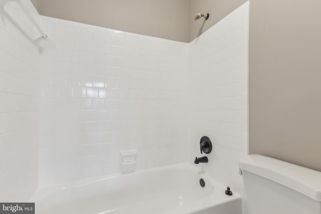 bathroom featuring bathtub / shower combination and toilet