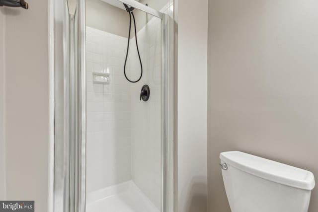 bathroom featuring walk in shower and toilet