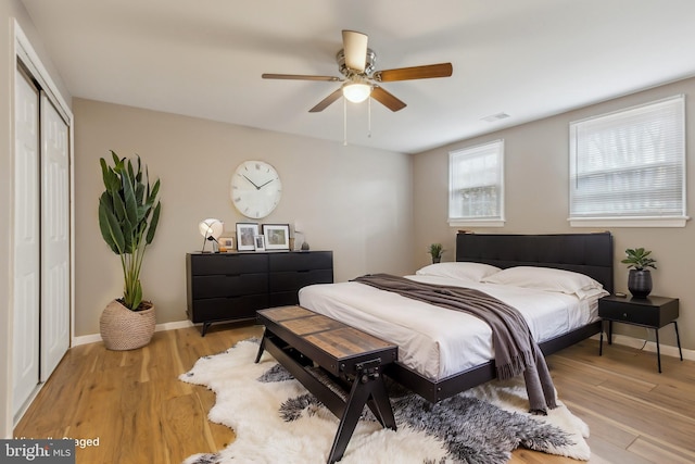 bedroom with ceiling fan, light hardwood / wood-style floors, and a closet