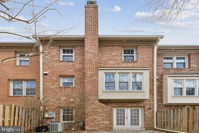 rear view of house with central AC, a patio area, and french doors