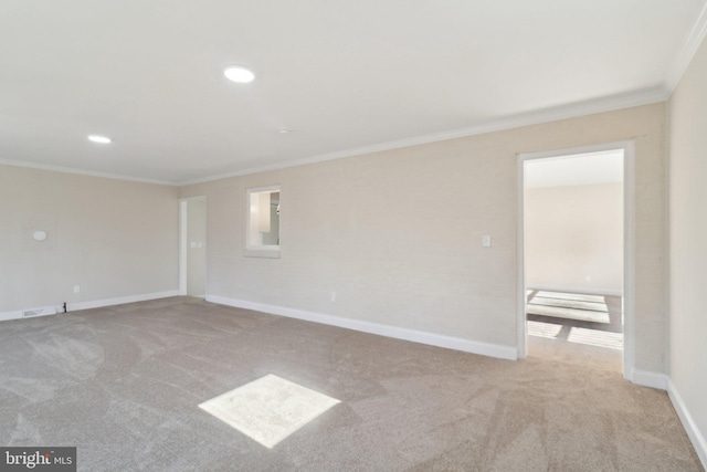 empty room featuring light colored carpet and crown molding