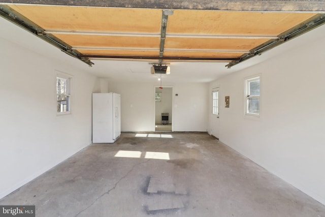 garage with white fridge and a garage door opener