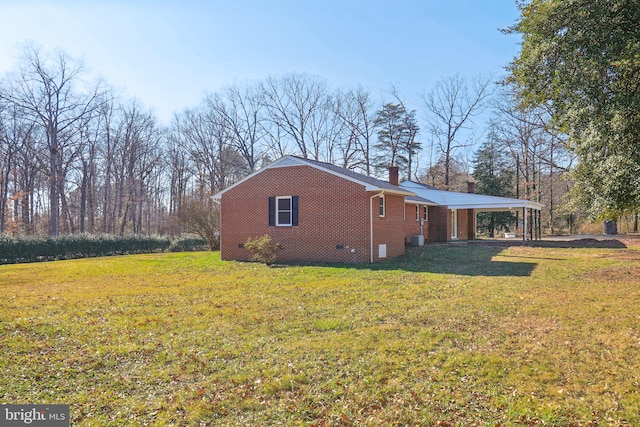 view of home's exterior with a carport, a lawn, and central AC