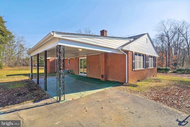 view of side of home with a carport and a yard