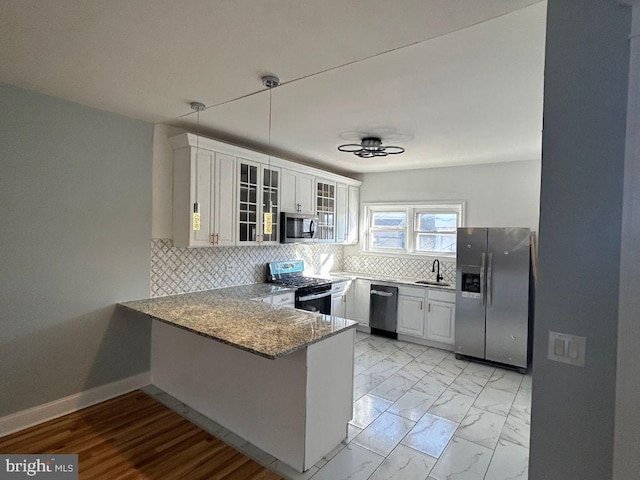 kitchen with sink, white cabinetry, light stone counters, kitchen peninsula, and stainless steel appliances