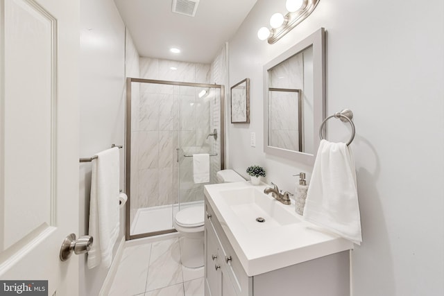 bathroom featuring vanity, a shower with shower door, and toilet