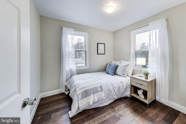 bedroom featuring multiple windows and dark hardwood / wood-style floors