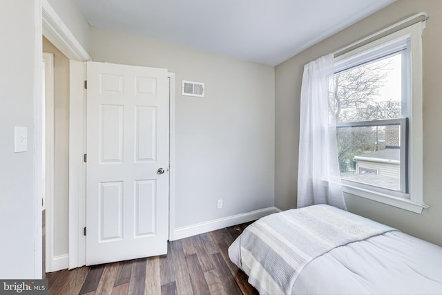 bedroom with dark wood-type flooring