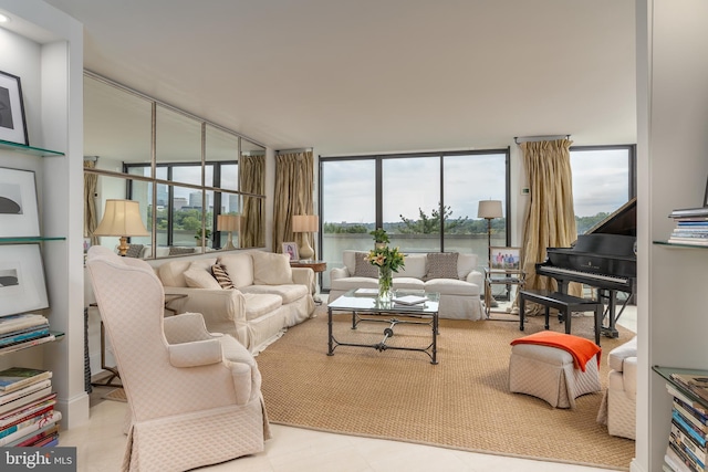 living room featuring a water view, a healthy amount of sunlight, and a wall of windows