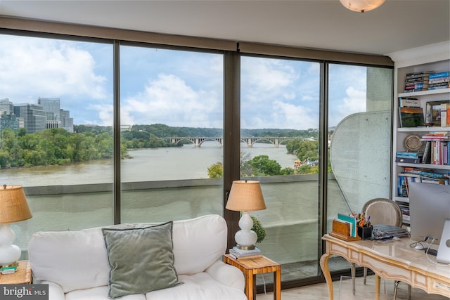 sunroom featuring a water view