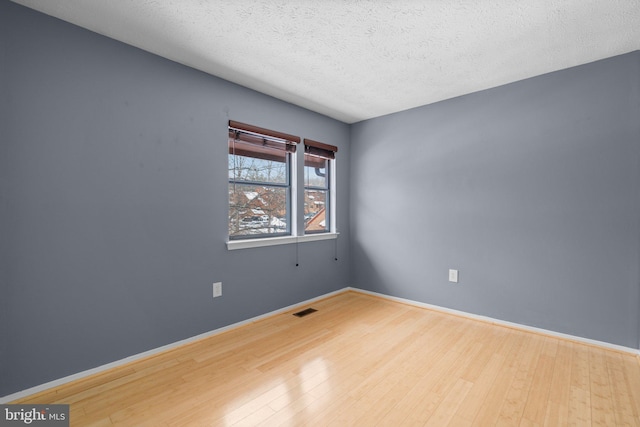 empty room featuring hardwood / wood-style floors and a textured ceiling