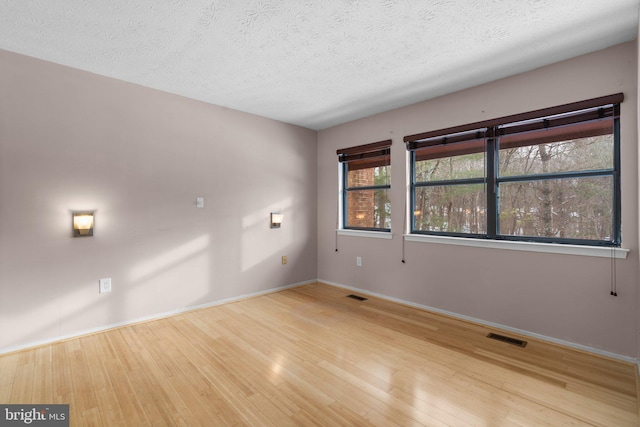 unfurnished room featuring hardwood / wood-style floors and a textured ceiling