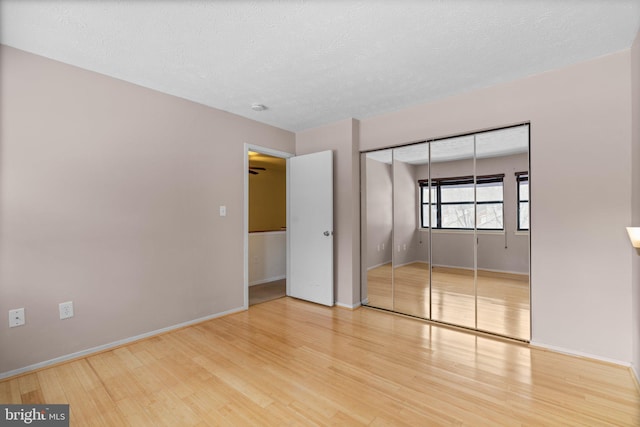 unfurnished bedroom with a closet and hardwood / wood-style flooring