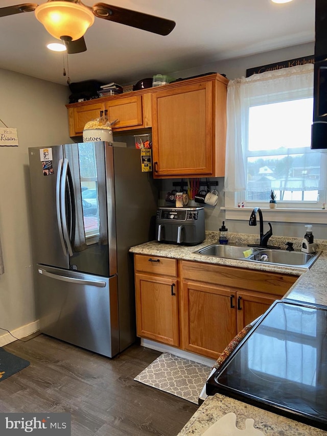 kitchen with ceiling fan, stainless steel fridge, dark hardwood / wood-style floors, sink, and stove