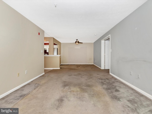 spare room featuring ceiling fan and carpet