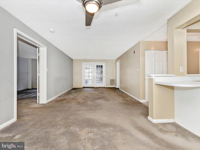 unfurnished living room with carpet floors, ceiling fan, and french doors