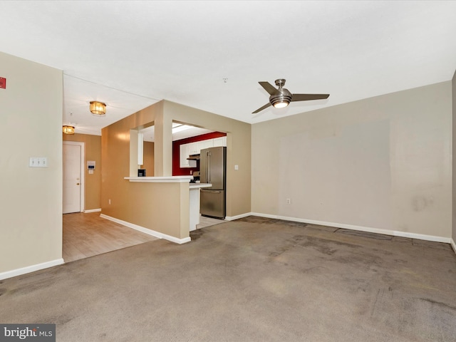 unfurnished living room featuring carpet floors and ceiling fan