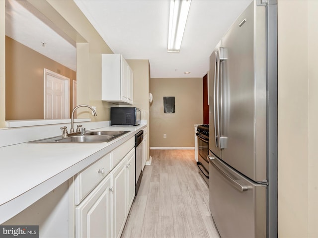 kitchen with white cabinetry, sink, light hardwood / wood-style flooring, and stainless steel appliances