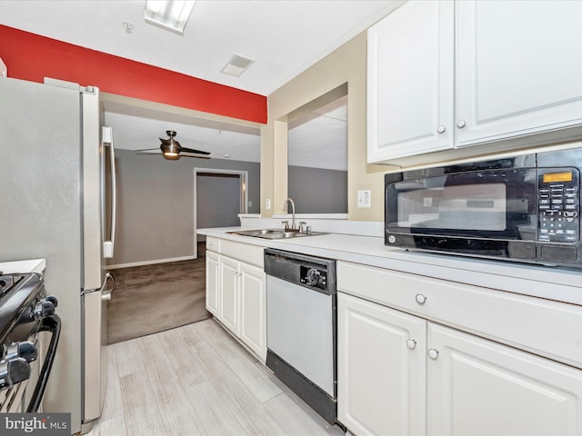 kitchen with stainless steel gas range, sink, white cabinetry, light wood-type flooring, and white dishwasher