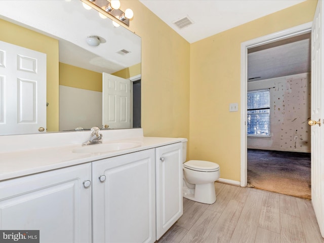 bathroom with vanity, hardwood / wood-style floors, and toilet