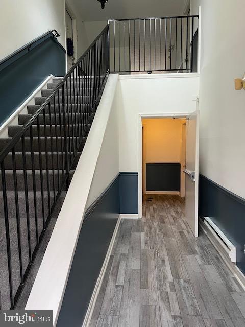 staircase featuring hardwood / wood-style flooring and a baseboard radiator