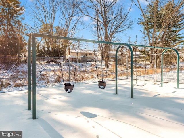 yard layered in snow featuring a playground