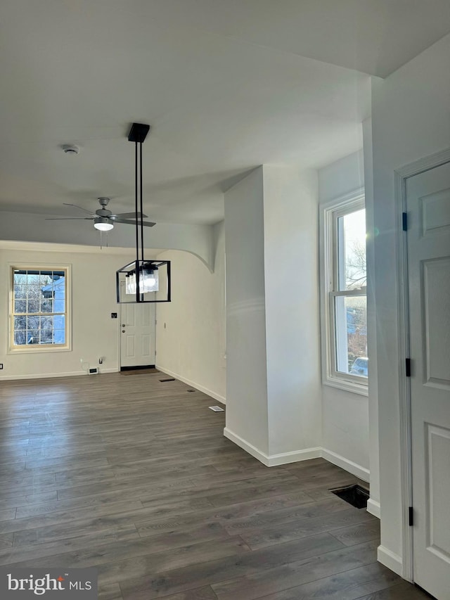 unfurnished living room featuring ceiling fan and dark hardwood / wood-style flooring