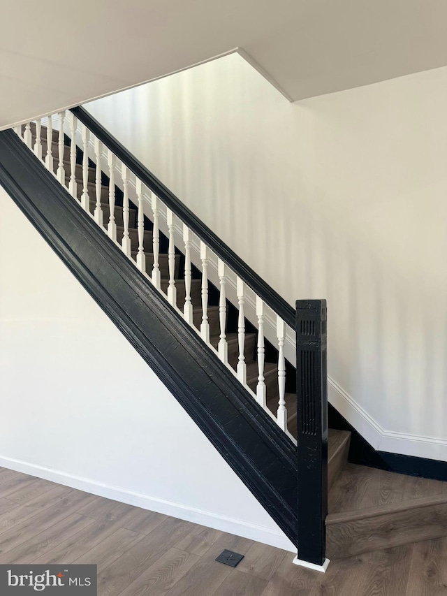 stairs featuring wood-type flooring