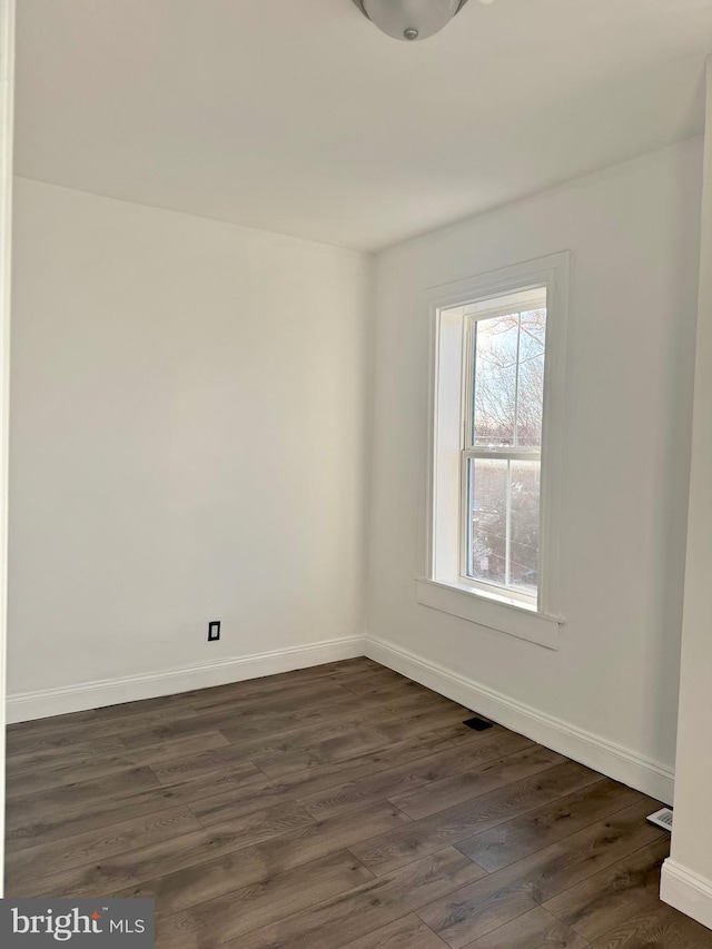 spare room with dark hardwood / wood-style floors