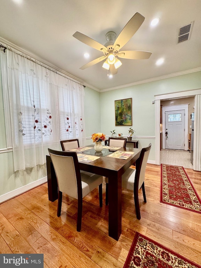 dining room with ceiling fan, crown molding, and light hardwood / wood-style floors