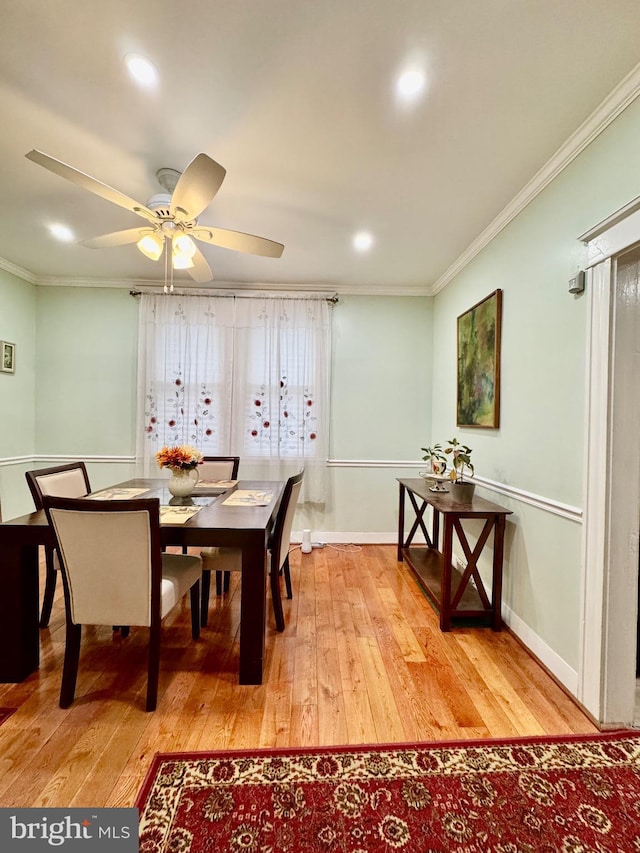 dining space with light wood-type flooring, ceiling fan, and crown molding