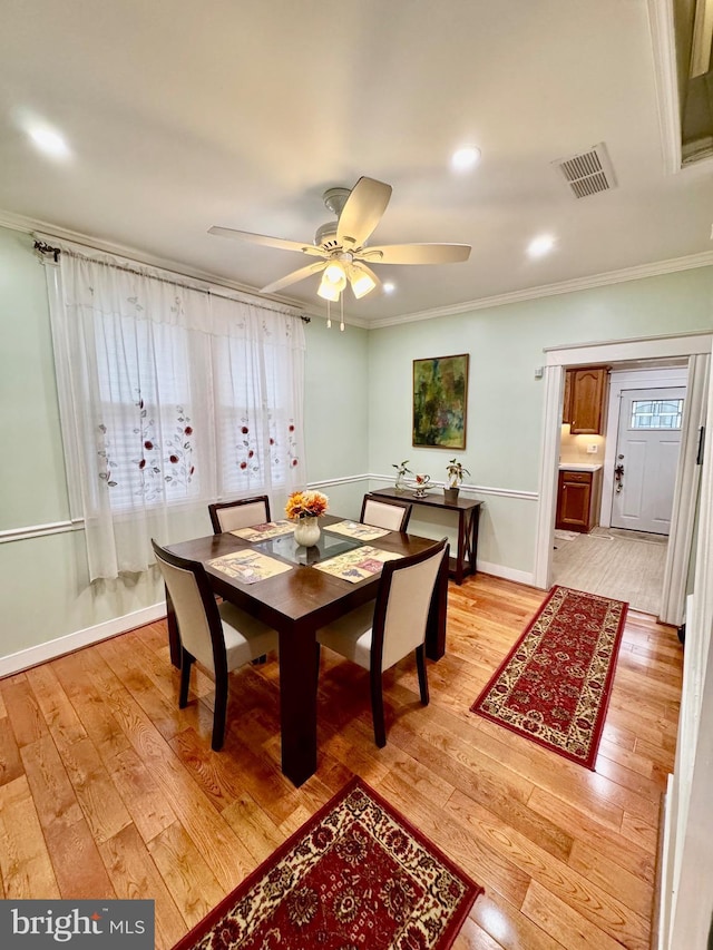 dining room featuring ceiling fan, light wood-type flooring, and ornamental molding