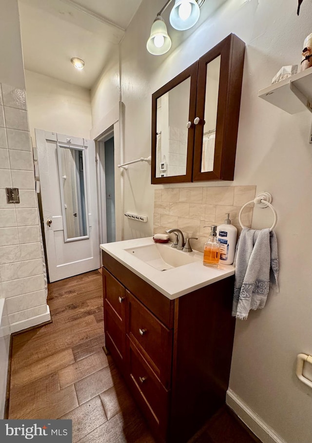 bathroom featuring decorative backsplash, hardwood / wood-style floors, and vanity