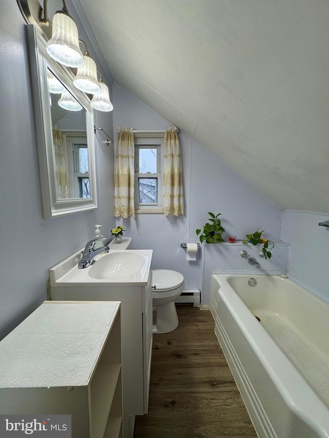 bathroom with hardwood / wood-style floors, vanity, lofted ceiling, a baseboard heating unit, and toilet