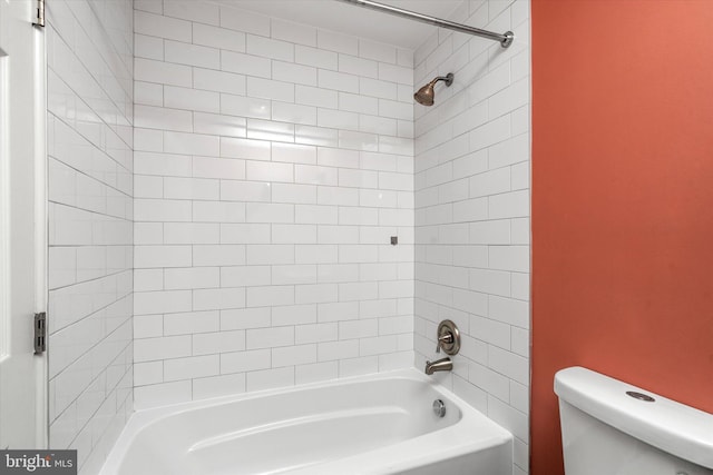 bathroom featuring tiled shower / bath combo and toilet