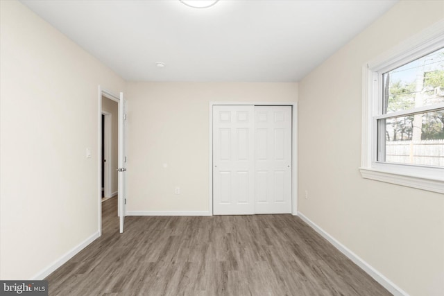 unfurnished bedroom with hardwood / wood-style floors and a closet