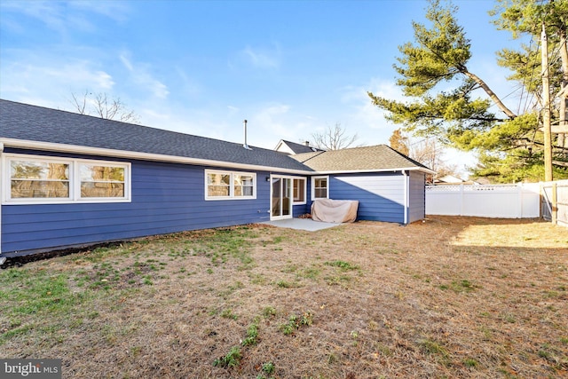 rear view of house with a yard and a patio