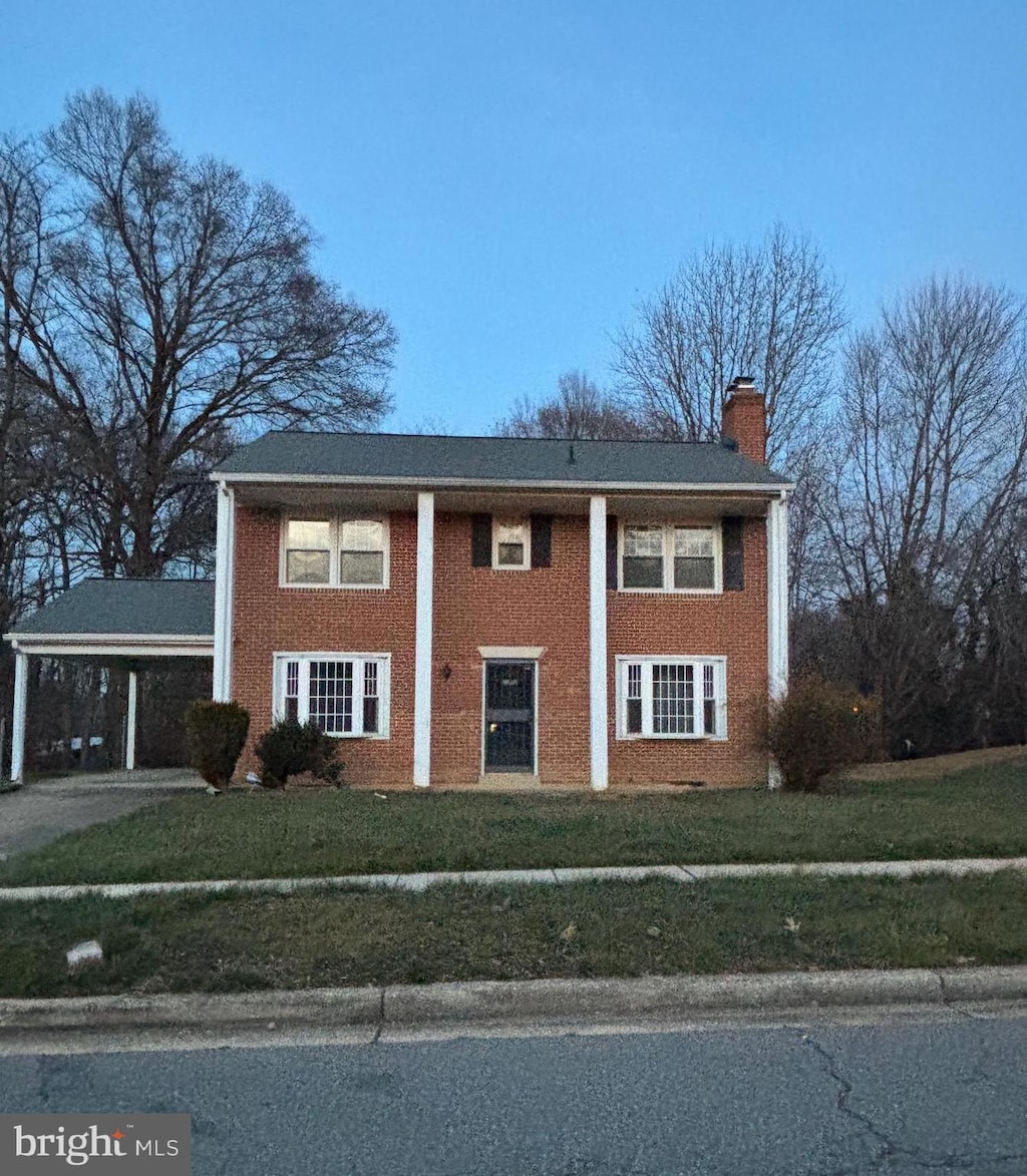 view of front facade with a carport and a front lawn