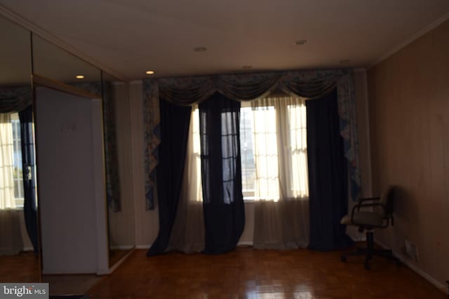 spare room featuring parquet floors and crown molding