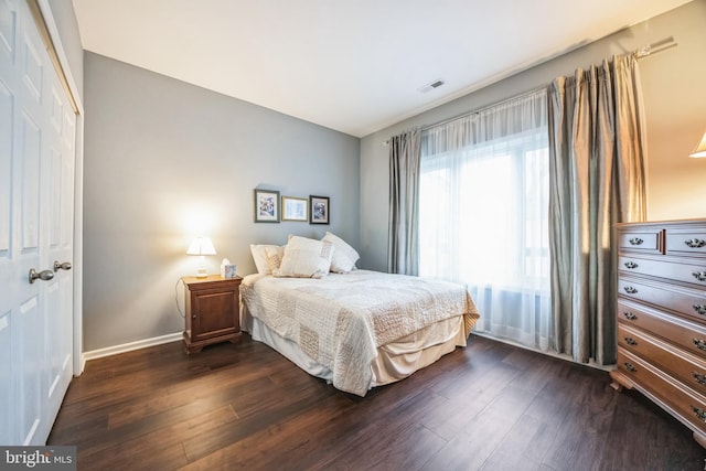 bedroom with a closet and dark hardwood / wood-style flooring