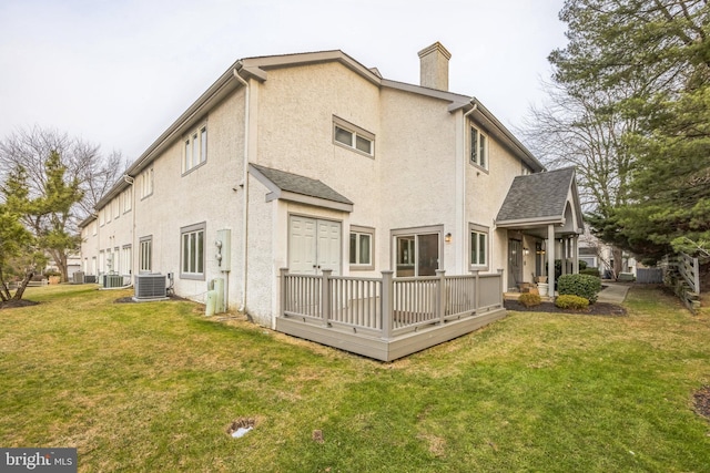 rear view of property featuring a wooden deck, cooling unit, and a yard