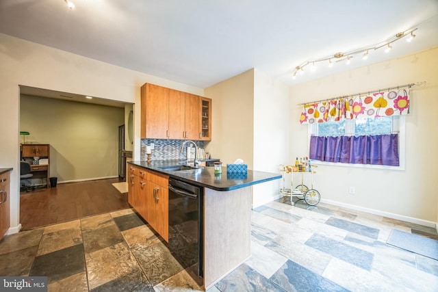 kitchen with tasteful backsplash, a kitchen bar, dishwasher, and sink