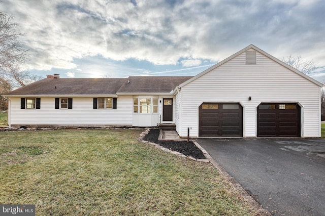 ranch-style house featuring a garage and a front lawn