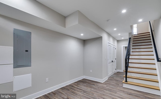 basement featuring hardwood / wood-style floors and electric panel